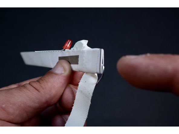 Now, leaving that newly secured and visible Maker Tape pathway uncovered, wrap another piece of tape around cleanly away from the LED toward the paperclip.