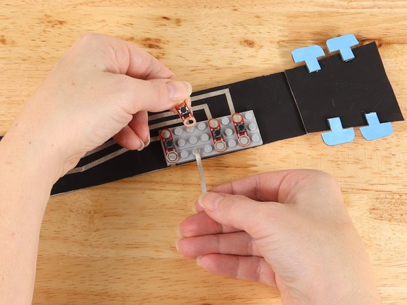 Remove the second button and add a piece of Maker Tape to the bottom stud as pictured.