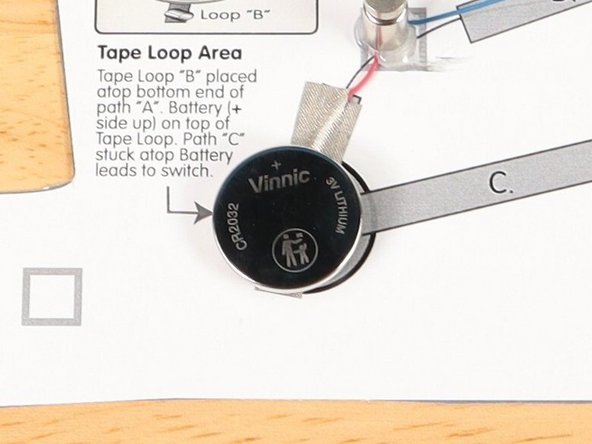 Make sure the Positive side of the Battery is facing upwards, with the Negative side stuck down to the tape.