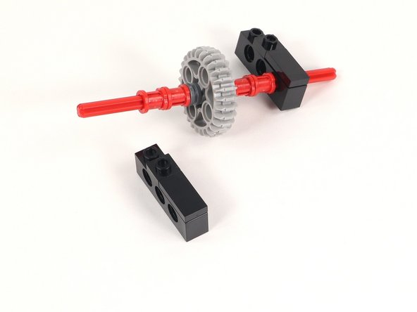 The axle should be through the first hole (under the 1x2 tile).