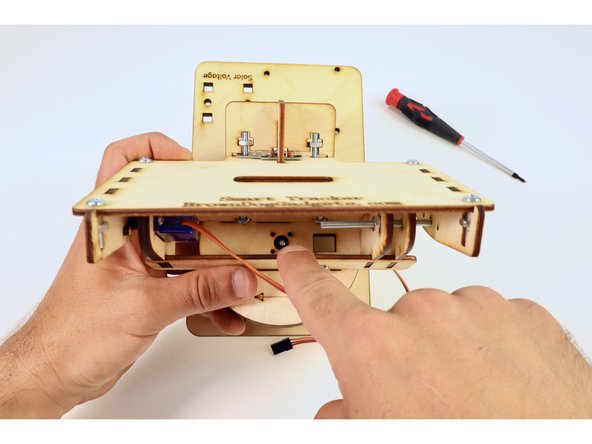 Press the servo horn  of the photoresistor array assembly on top of the servo axle from the assembly you just finished and thread the small screw through the hole above the servo axle as shown.