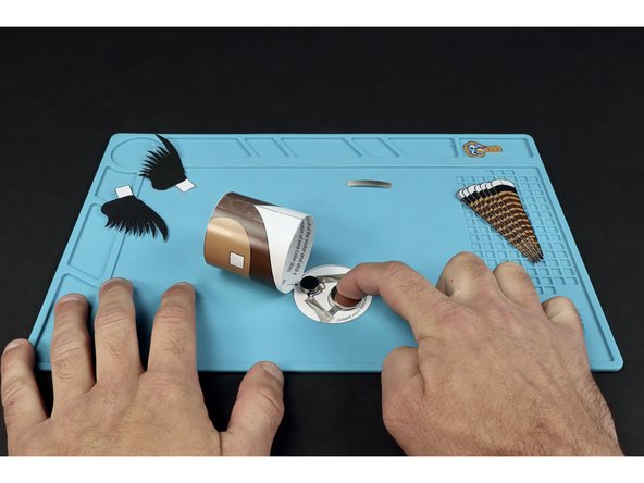 Stick the battery onto the tape loop so that the positive side faces UP.