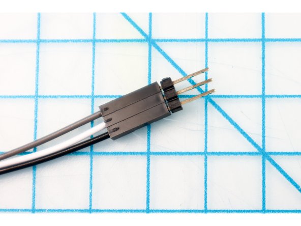 Plug the jumper wires into the NeoPixel string using three long headers as shown.