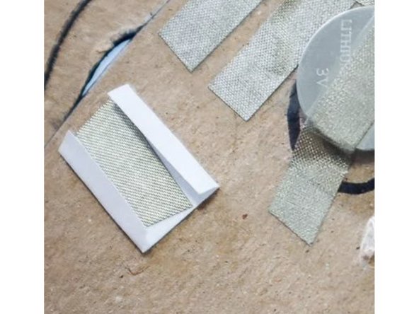 Tape the flaps in place over the two spots where the circuit is broken. Squeezing both of these switches will now close the switch.