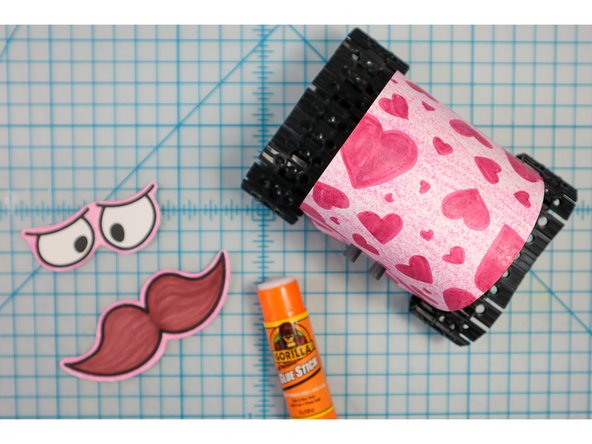 Use glue or tape to attach the face pieces to the body.