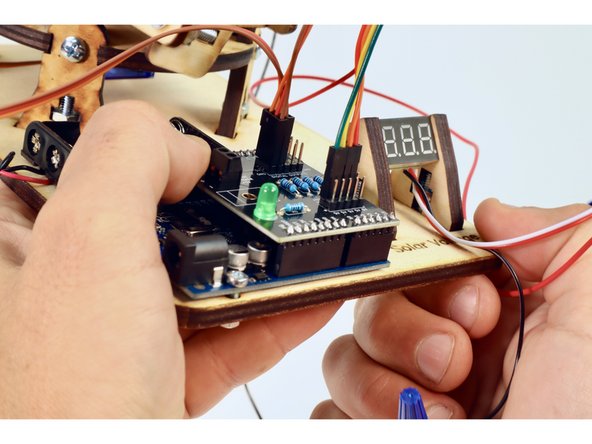 Note the color of the topmost wire  already plugged in (green in our photo...but yours may be a different color). Find the opposite end of that wire and plug it into the analog pin labeled A0 on the Arduino shield.