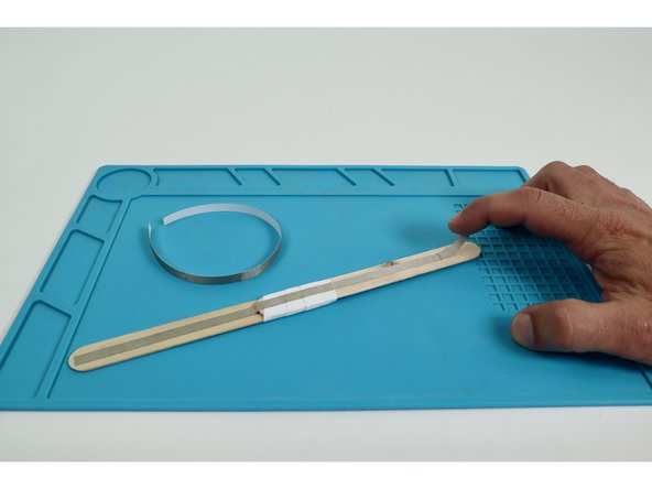 Place each of the two long Maker Tape pieces so they run end-to-end down the middle of each side of the wand handle.