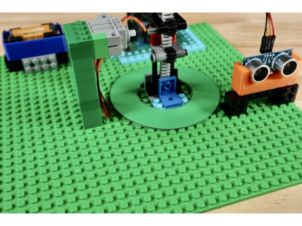 With all subsystems spaced correctly, connected, and tested it's time to add the final decorations. The hat pieces will all need to be slid down over the gear rack which (for testing purposes) should still be connected to the servo via the axle connector. Remove that axle connector to allow for placement of the leprechaun hat and brim.