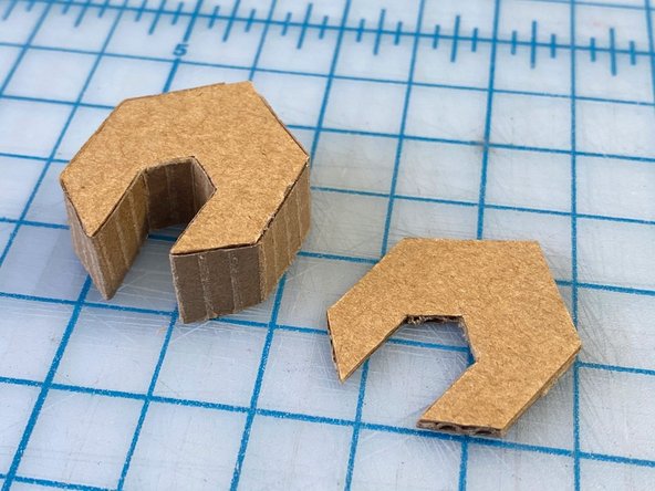 We sketched a wrench shape because we thought it was the most iconic and aesthetically pleasing robot hand. We cut the shapes out twice, one for each hand, and outlined them with the paper that we pulled off of one side of the cardboard (This made it easier to fold and manipulate around the small corners).