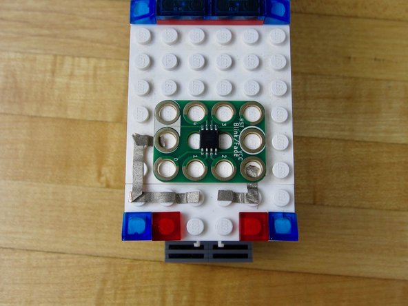 Place a line of tape from the other side of your Screw Terminal to the nearest Common Ground hole on the Blink/Fade Board.
