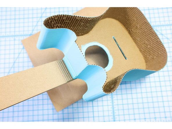 Glue the head piece to the top of the neck and paint the guitar with craft paint.