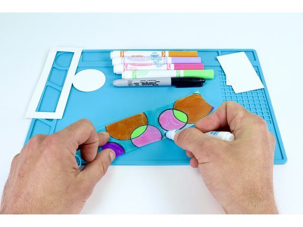 Use a black marker to create designs on your tracing paper rectangle that break it up into sections. Then color the sections in with markers as you wish.  Anything goes!