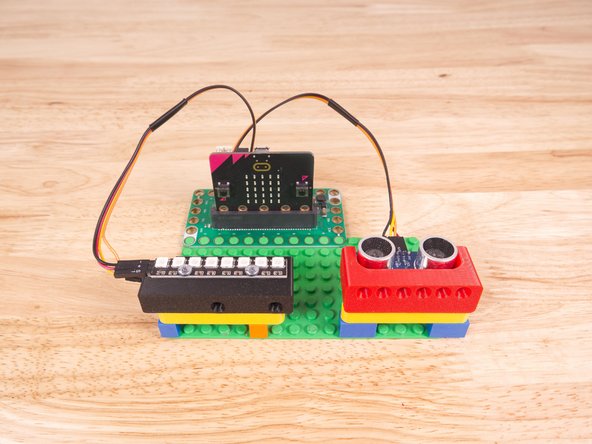 We used a 3D printed part we designed to hold the Distance Sensor and NeoPixel Strip in place on the LEGO baseplate.