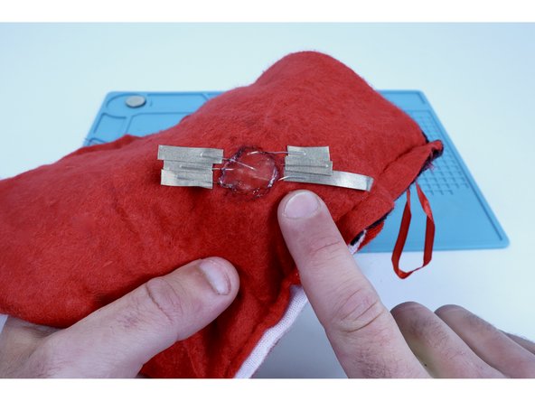 Using 3 overlapping pieces per side on your overall cluster, stick half of each individual piece of Maker Tape that you prepared to an LED leg and fold over on itself to stick the sticky sides together. This is shown in photos one and two.