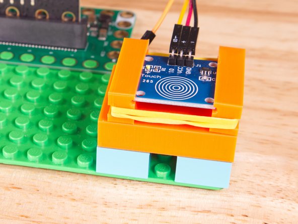 We used a 3D printed holder we designed to hold the Cap Touch Sensor in place on the LEGO baseplate.