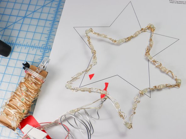 Wrap the tail around in a circle to make a cone-like spiral. If you are placing this project on a live tree, you can slip this cone over the topmost branch to attach it to the tree.