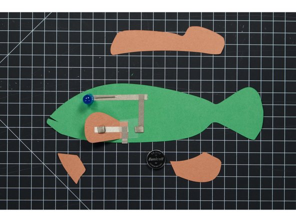 We’re going to make two small tape loops using Maker Tape. One will hold the battery down to the negative tape line, while the other will hold the fin down to the top (positive side) of the battery.