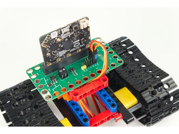 The photos were taken with a Bit Board V1 during development and it lacks the Blue Pins. (We are in the process of updating the photos.)