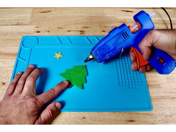 Squeeze a small dot of hot glue onto the top of the foliage piece where the star should go and press that piece into place as shown.