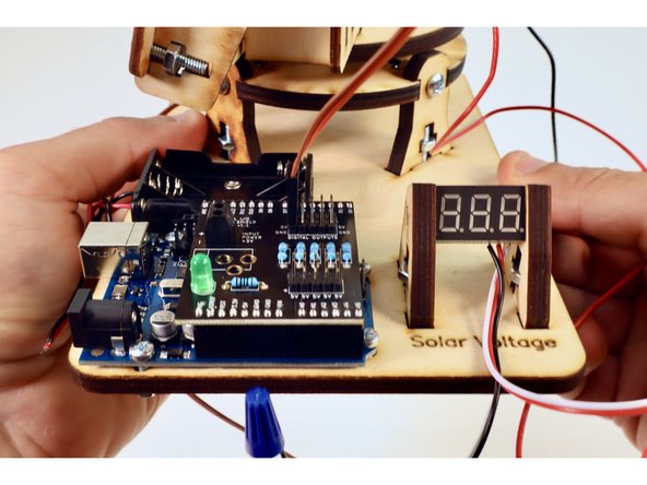 Take the wires from the uppermost servo and plug them into the row of pins labeled D6 as shown in photo one. Orient the plug so that the brown wire connects to the column of pins labeled "GND".
