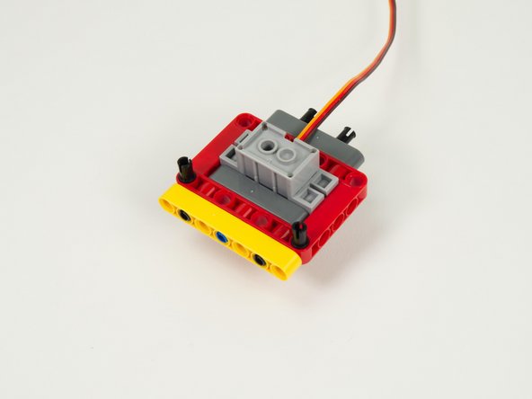 Add another yellow 7 hole beam to the red frame using the two black pins added in the previous step.