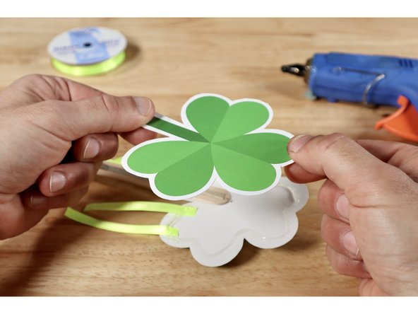 Carefully place the ends of your ribbon atop the glue and press them into the glue with something that is NOT your finger. Remember: The glue is HOT.