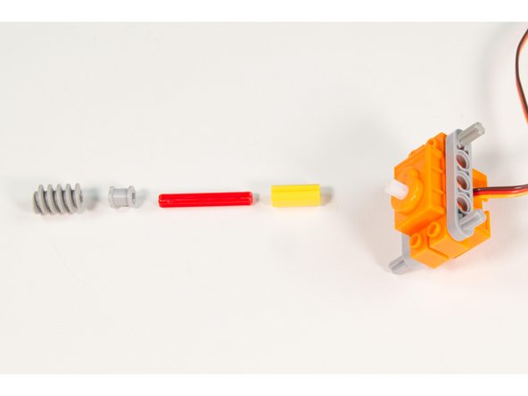 Press the LEGO Axle Connector (Smooth with ‘x’ Hole) onto the servo shaft.
