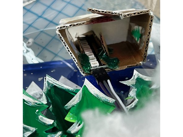 I made a tiny gingerbread house out of cardboard, with the chimney sized to fit the NeoPixels stick.