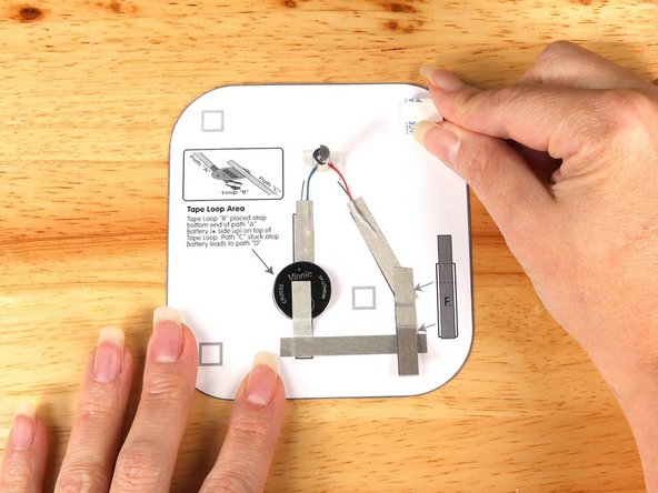 Add four small pieces of double-sided foam tape to the squares around the outline of the monster.