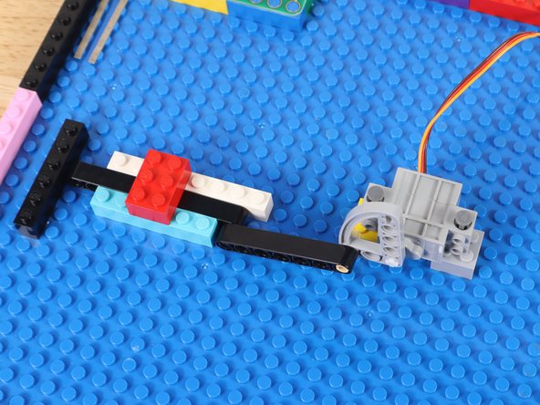 Add one LEGO brick over the top of the other bricks making the track. This prevents the gate from being able to pop up out of the track.