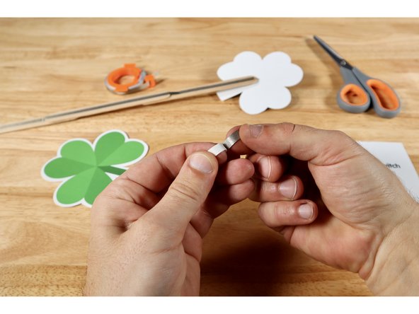 Measure, cut, peel, and stick a piece of Maker Tape that is about 2x the length of the long Positive (+) LED Leg.