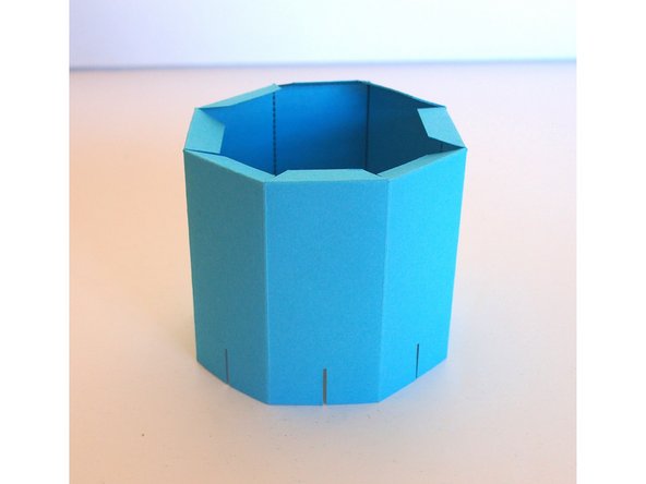 Glue the body into an octagon shape (the two sections on either end should overlap on top of each other to form 8 sides)