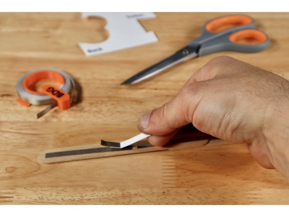 With the Maker Tape side facing down, align the switch over the gap as shown so that the conductive part bridges the gap. Use a small piece of Maker Tape to secure it to the wand handle from the top.