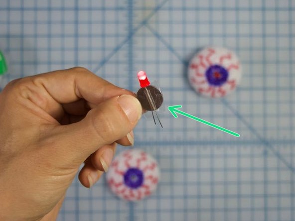 Make sure the battery is pushed up against the red cap of the led, and tape the battery and legs together securely.