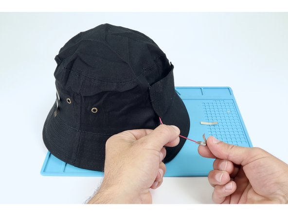 Cut two small pieces of Maker Tape and sandwich the metal ends of each of the two wires leading from the battery pack just as you had each of the individual LED legs earlier. The black wire is negative and the red wire is positive.