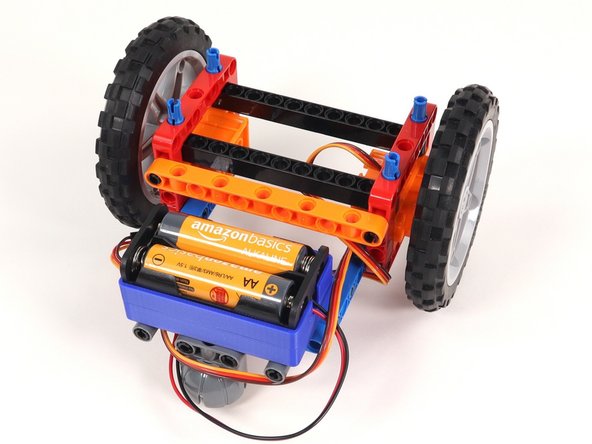 Add the orange beam to the back of the Rover. The black pins should go in the top holes of the red frames.