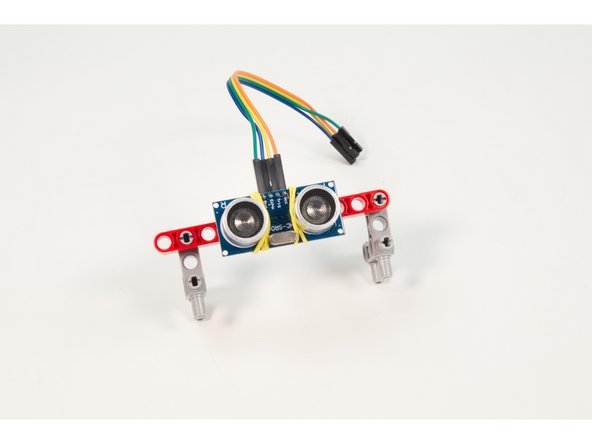 Once again we chose to use the most advanced mounting device we could find. A rubber band! We rubber banded the sensor to the beam with the Jumper Wires facing up.