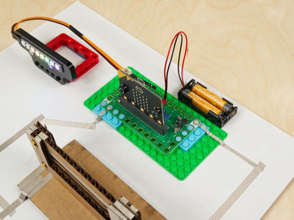 When connecting Crazy Circuits projects to paper circuits-style projects we usually stick everything down to a piece of scrap cardboard.