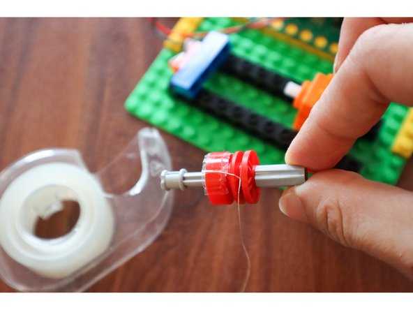 Tie a piece of thread that's long enough to reach the location of your spider to the wheel rim, and secure it with a piece of tape.