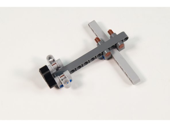 Add 2 LEGO Cross Block 90° 1 x 2 (Axle/Pin) by pushing the 2 LEGO Axle 4 with End Stop parts into place.