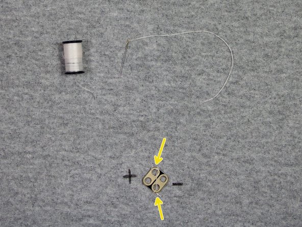 Place the LED over the spot where the safety pin is, with the LED facing down toward the fabric.