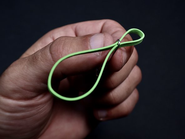 To build the launcher, thread your rubber band through the remaining paperclip  to form two loops as shown.