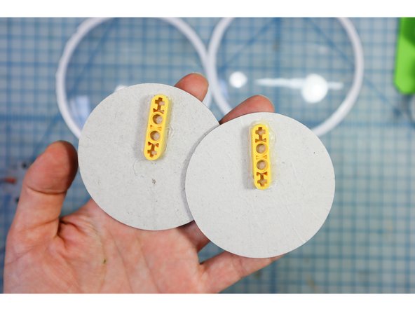 Reuse the googly eye pupils, and glue the motorheads to the back, positioning the &quot;+&quot; a bit away from the edge.