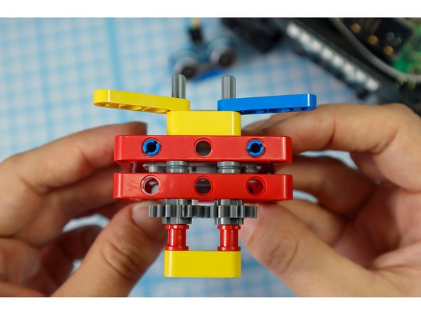 Continue adding components to the axles as shown: the yellow beam, a half beam on each axle, and full red bushings on each axle.