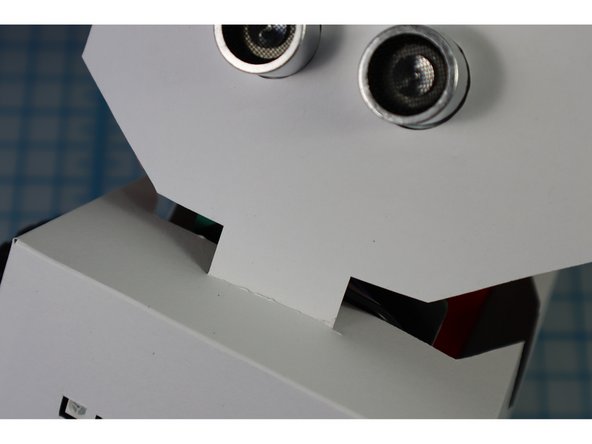 Insert the front head tab through the slit in the front of the body.