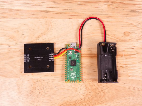 Solder the red wire to the VSYS pin hole. Note that it is the second hole from the end. (The labels on the bottom are not perfectly aligned due to the mounting holes.)