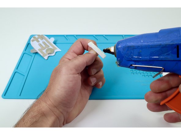 Peel the backing off of a self-stick safety pin and add a bead of hot glue.