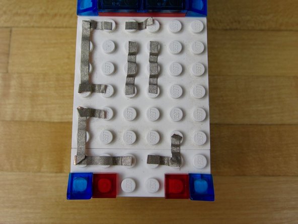 Use a small piece of tape to connect the Grounds (white, Negative sides) of the LEDs together.