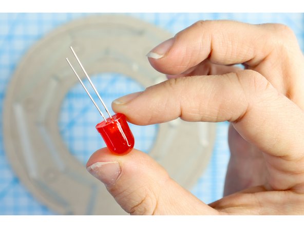 The LEDs have a long positive leg and a short negative leg. Note which is which and bend the LED's legs flat as shown.