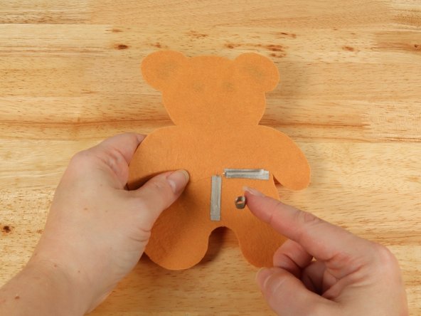 Make a loop of tape (sticky side out) using a short piece of Maker Tape, and stick it atop the end of the path coming from the short (Negative) LED leg.